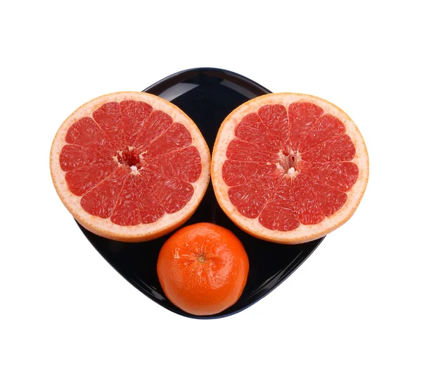 Pomelo rojo maduro. La fruta cortada en un plato azul oscuro —  Fotos de Stock