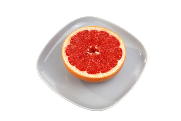 Pomelo rojo maduro. La fruta cortada en un plato azul — Foto de Stock