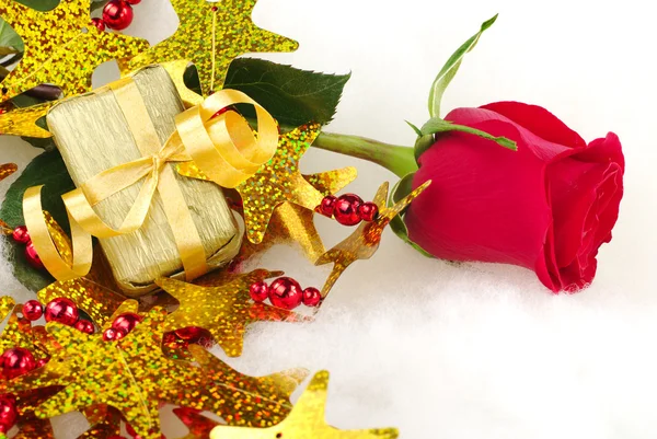 Červená růže a zlatý dárek — Stock fotografie