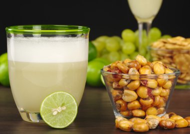 The Peruvian cocktail, Pisco Sour with the Peruvian snack, roasted corn, called cancha and grapes, limes, Pisco Sour and habas (Peruvian roasted beans) clipart