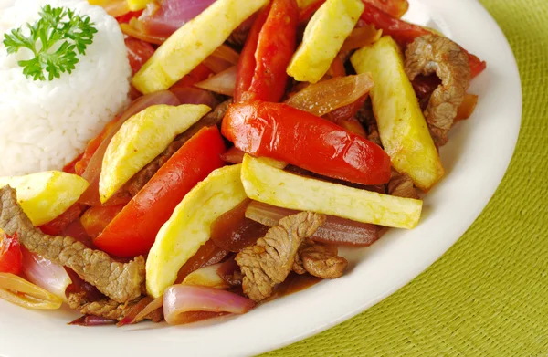 典型的秘鲁菜 被称为 Lomo Saltado 由牛肉 西红柿和伴有炸的土豆和米饭 选择性焦点 — 图库照片