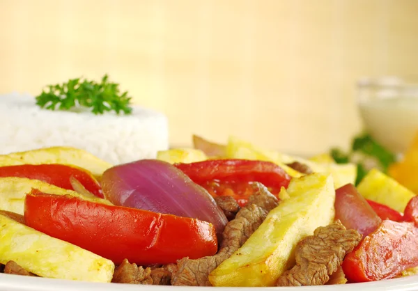 典型的秘鲁菜 被称为 Lomo Saltado 由牛肉 西红柿和伴有炸的土豆和米饭 选择性焦点 — 图库照片