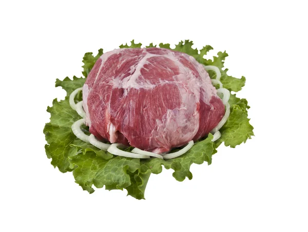 Ein Stück frisches Schweinefleisch in Salatblättern mit Zwiebeln — Stockfoto