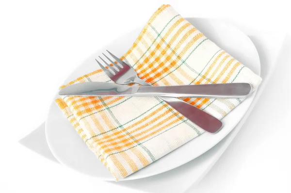 Servilleta, doblada en un plato con cuchillo y tenedor — Foto de Stock