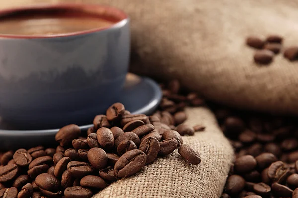 Koffiebonen en cup met koffie — Stockfoto