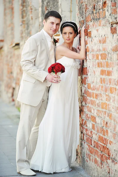 Brautpaar Für Eine Alte Backsteinmauer — Stockfoto