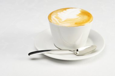 White cup of cappuccino with brown and white foam on top. Object on white clipart