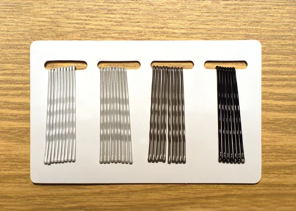 Quatro grampos de cabelo de grupo no modelo branco sobre fundo de madeira marrom — Fotografia de Stock