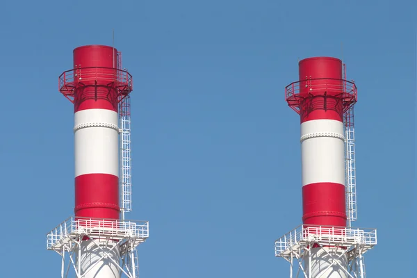 Mavi gökyüzü üzerinde iki endüstriyel duman boruları — Stockfoto