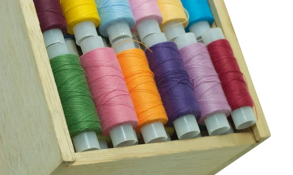 Bobinas con hilos de color en caja de madera aislada en blanco — Foto de Stock