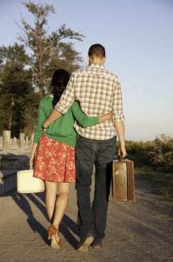 Couple walking with luggage in hand clipart