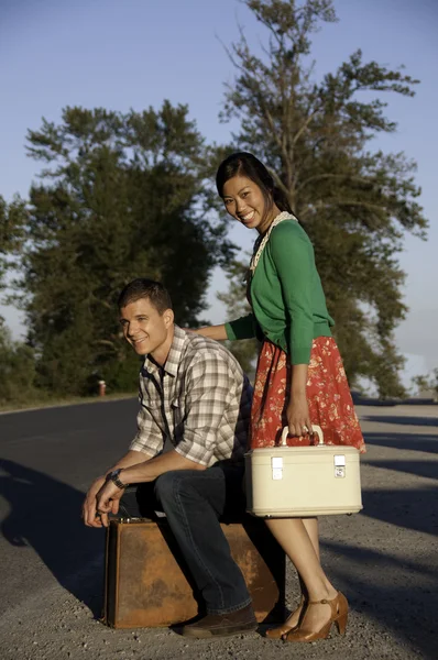 stock image Boy and girl at roadside with suitcase