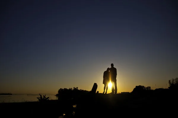 Silouette of two standing on a bank — Stock Photo, Image