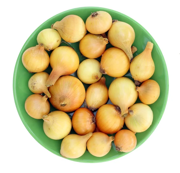 Κίτρινα κρεμμύδια σε ένα πράσινο πιάτο — Φωτογραφία Αρχείου
