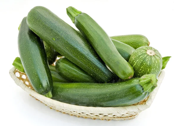 Fresh small green vegetable marrows in a wattled small basket — Stock Photo, Image