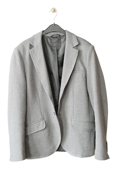 De oude grijze jas hangt een hanger — Stockfoto