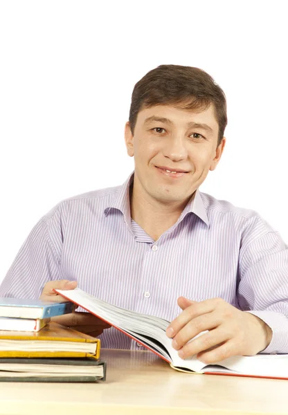 Молодой человек с книгами на столе — стоковое фото