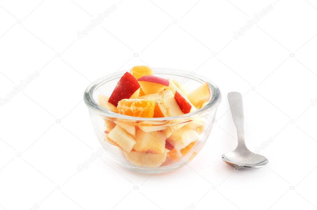 Healthy breakfast consisting of fruit salad in the bowl and a spoon isolated on white with clipping path