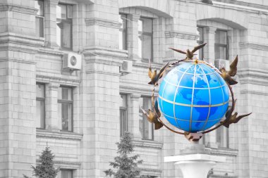 Colored globe on black and white facade administrative house in clipart