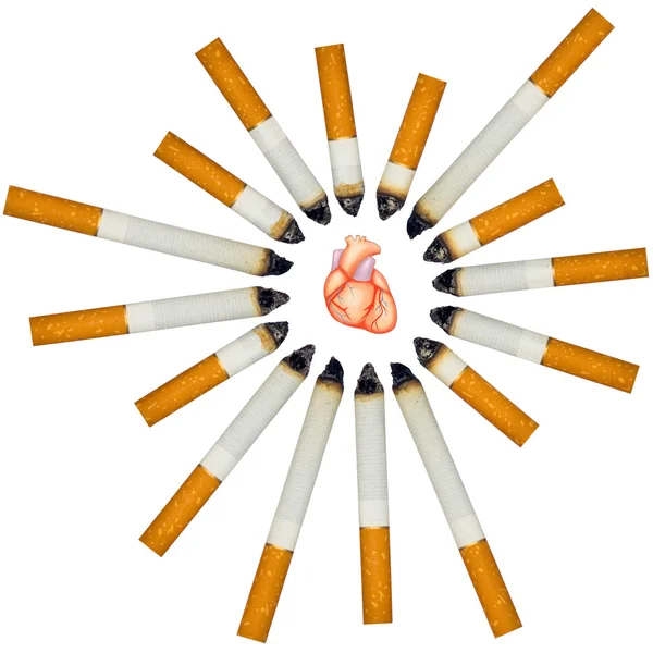 Small human heart against numerous cigarettes — Stock Photo, Image