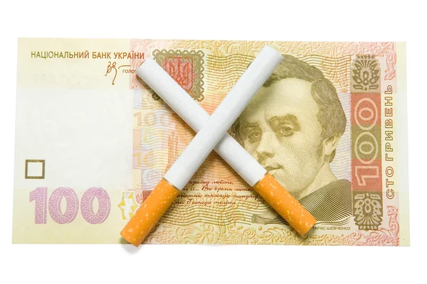 Two cigarettes crossed over one hundred hrivna bill — Stock Photo, Image