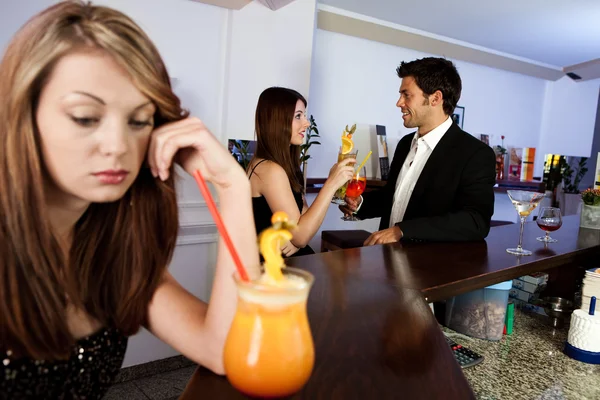 Sad women and happy couple in the background — Stock Photo, Image