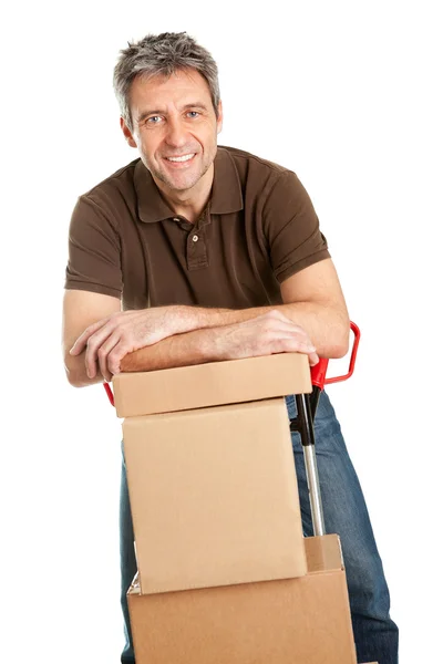 Entrega hombre con camión de mano y pila de cajas —  Fotos de Stock