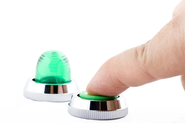 白い背景の上の緑のボタンを押す指 — ストック写真