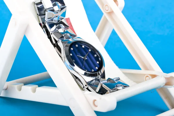 Ένα Ρολόι Χειρός Που Αναπαύεται Στις Ξαπλώστρες Μπλε Φόντο — Φωτογραφία Αρχείου