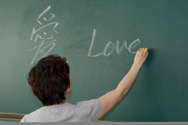 Stock image Female teacher writing on a blackboard