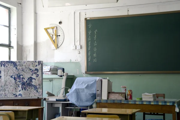 stock image A teacher's desk and a chalkboard in an schoolroom
