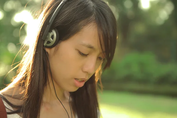 Flickan njuta av musik med hörlurar — Stockfoto