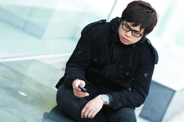 Lässige asiatische Mann SMS auf Handy — Stockfoto