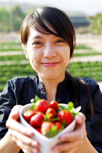 Sorriso menina dar-lhe tigela de morangos — Fotografia de Stock