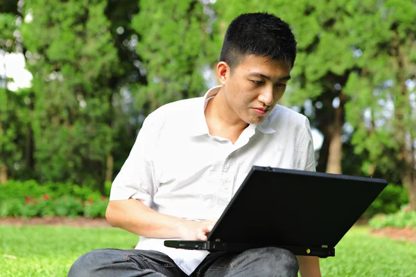 Człowiek za pomocą laptopa w parku — Zdjęcie stockowe