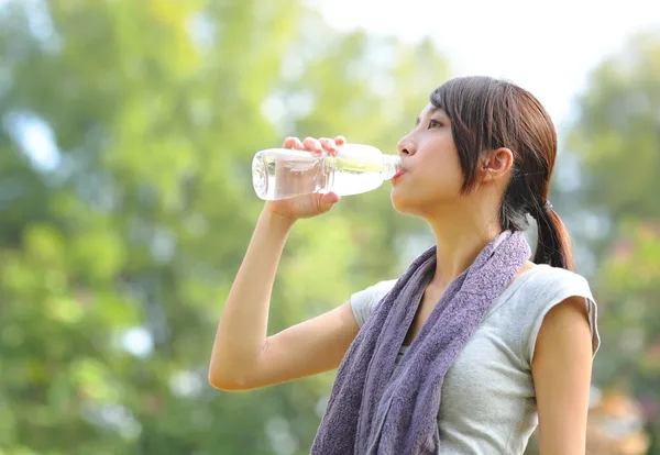 Женщина пьет воду после спорта — стоковое фото
