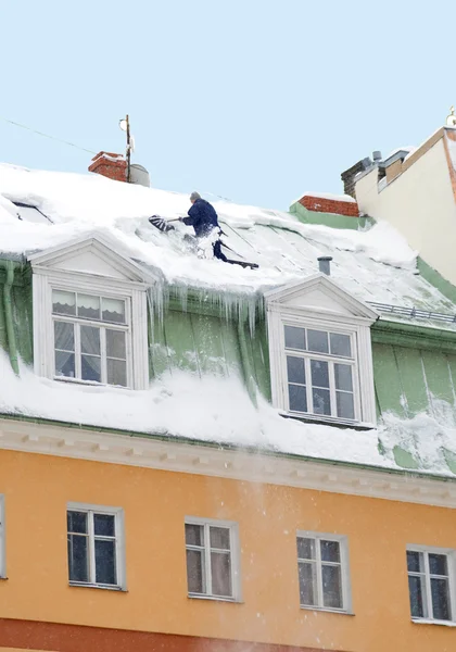 I lavoratori puliscono la neve da un tetto di casa — Foto Stock