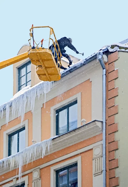 Arbeiter Reinigen Schnee Und Eiszapfen Vom Hausdach Stockbild