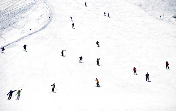 Mass descent of mountain skiers from hillside — Stock Photo, Image