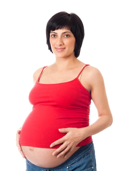 Улыбающаяся беременная женщина на белом фоне — стоковое фото
