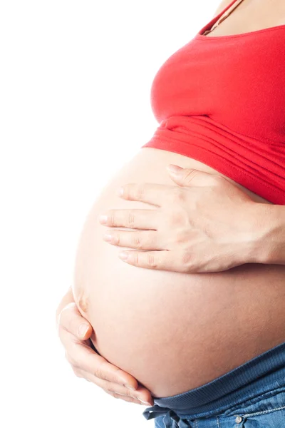 Gravid kvinna som håller sin mage med händerna Royaltyfria Stockbilder