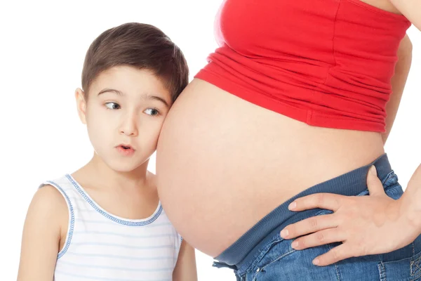 Surpris garçon écoutant le ventre de la mère enceinte — Photo