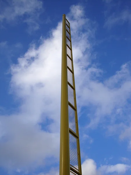 Sarı faul direğine bulutlu mavi gökyüzü karşı — Stok fotoğraf