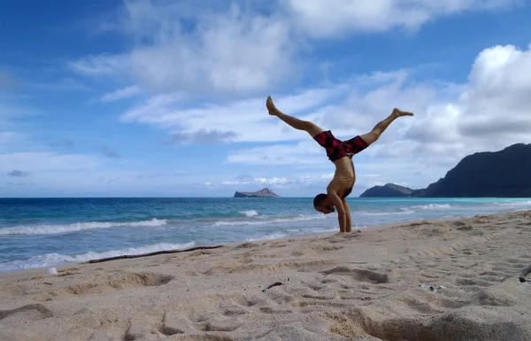 Hombre hace handstand en la playa de Waimanalo en Oahu dividiendo su —  Fotos de Stock