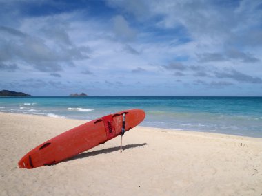 Life Guard Rescue Surfboard sits on Waimanalo Beach with Islands visible in the distance. clipart