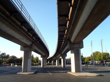 Parking lot under a Public Transit overhead rail-line clipart