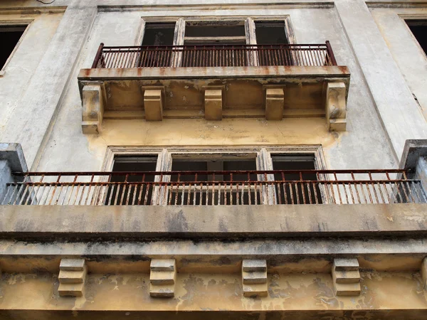 Balconies of a old worn building missing it 's windows — стоковое фото