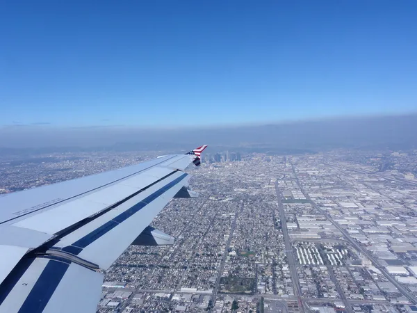Olhando para uma asa de avião com vista para o centro de LA — Fotografia de Stock