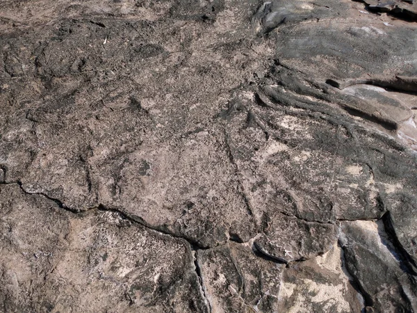 Rachado resistido rocha Lava com pedaços de areia no topo — Fotografia de Stock