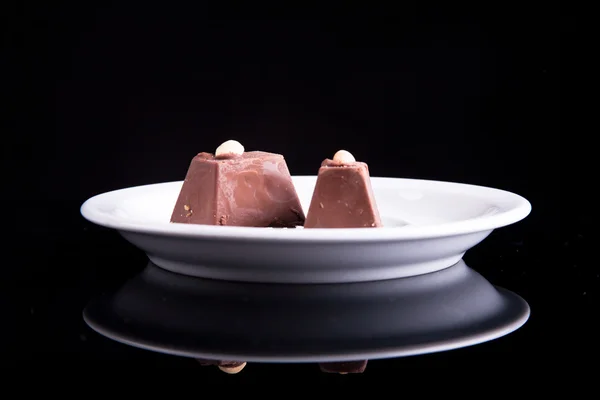 stock image Chocolate with nus on plate on dark background